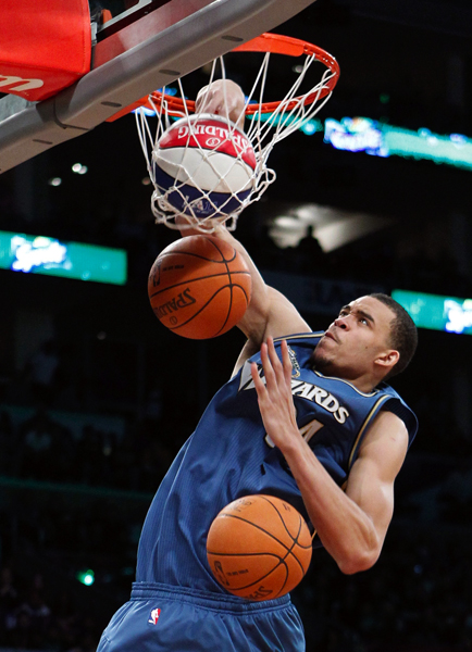 Wizards' McGee dunks three balls during the slam dunk competition at the NBA basketball All-Star weekend in Los Angeles